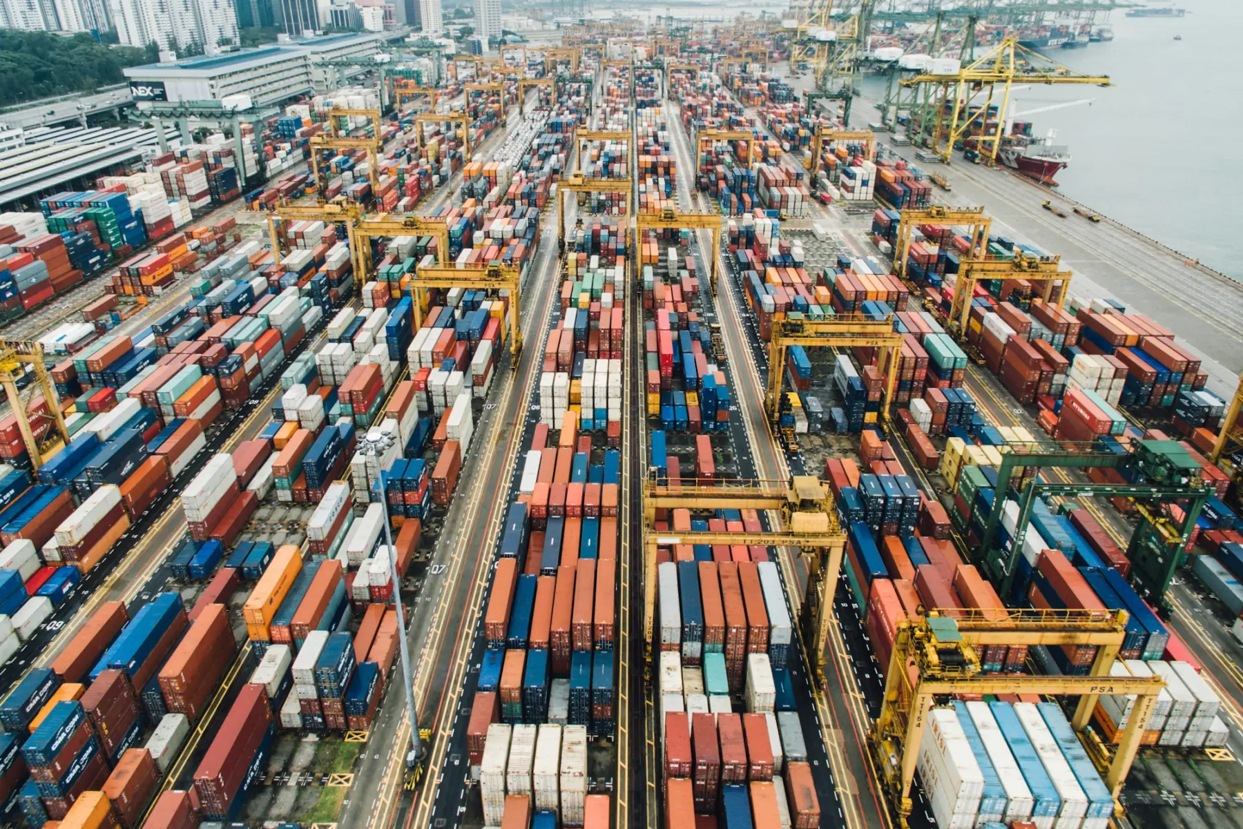 Container terminal seen from above, with gantry cranes over stacked containers
